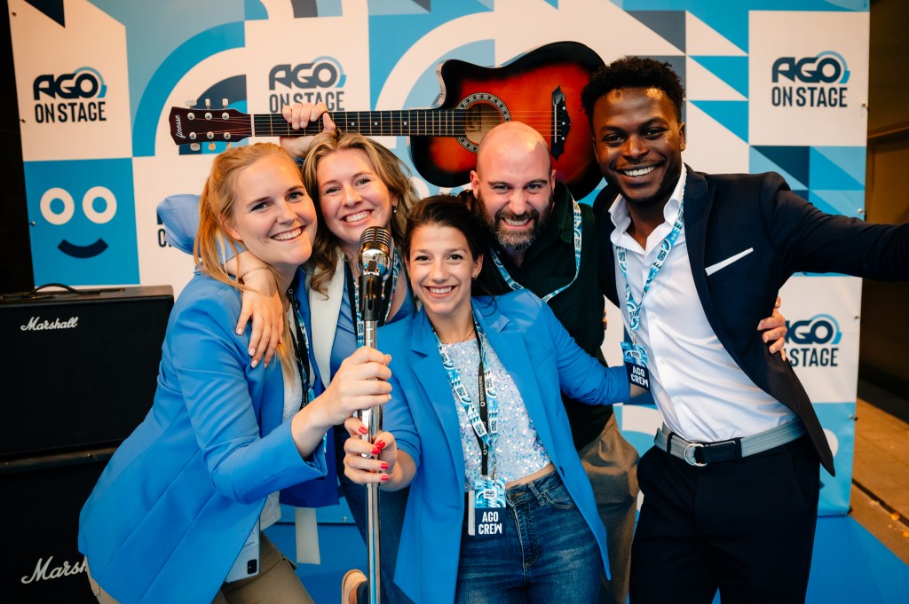 five smiling colleagues in a photo booth at a corporate event at capitole in ghent belgium